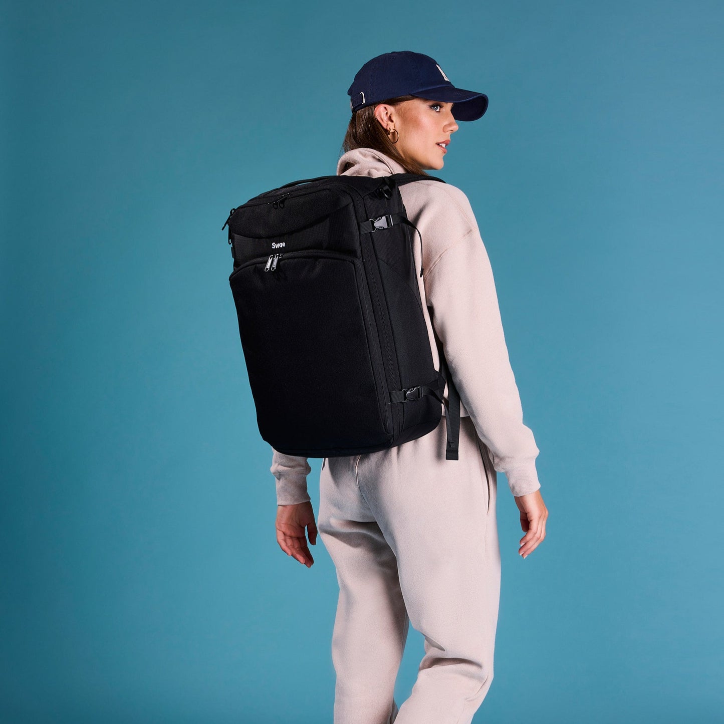 Female traveler wearing the Swae Flow 40L Travel Backpack, demonstrating its sleek, ergonomic design and comfortable fit for everyday adventures.