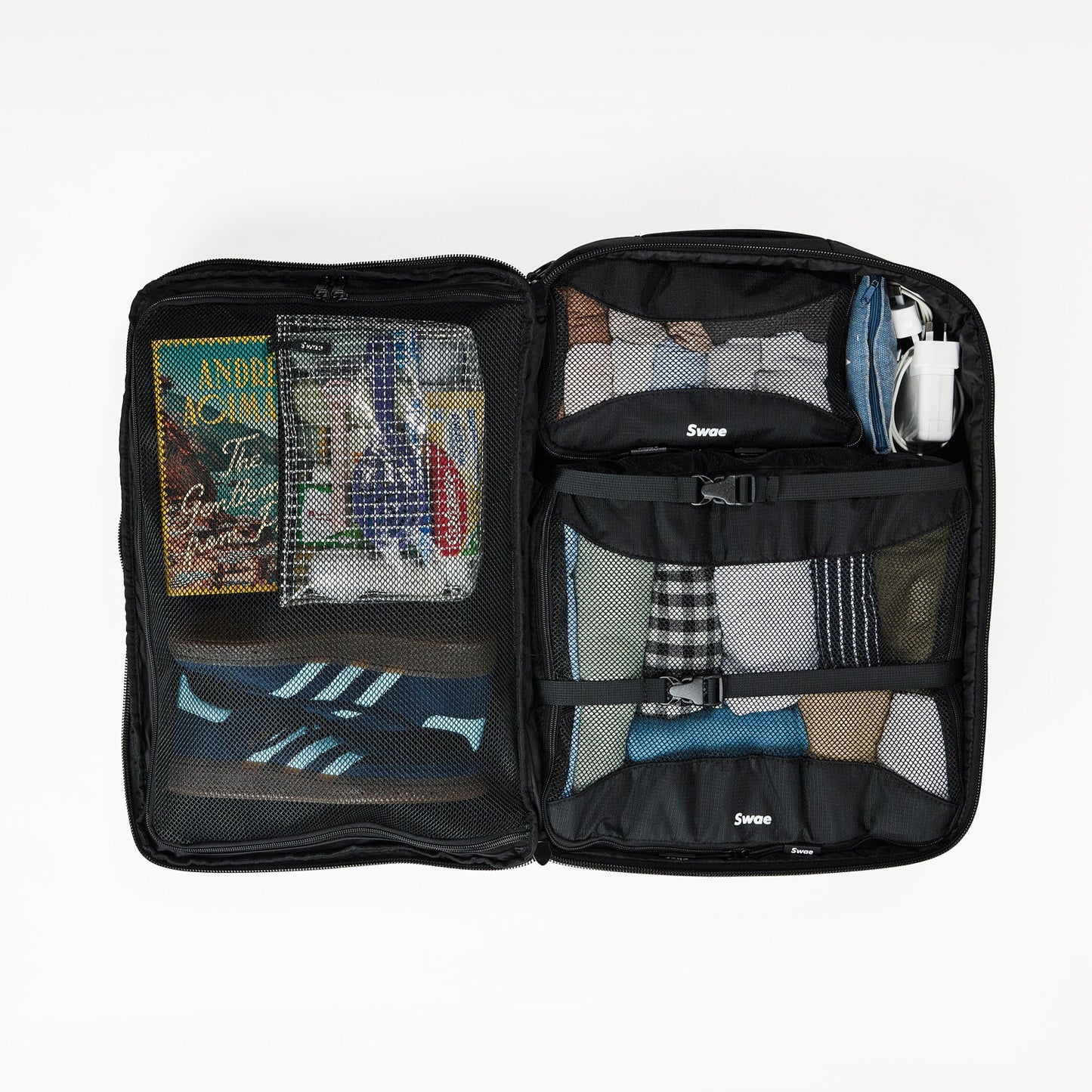 Interior view of the Swae Flow 40L Travel Backpack, featuring a spacious suitcase-style main compartment with a zippered mesh divider, internal compression straps to secure belongings, and an oyster-style opening for easy packing and access.