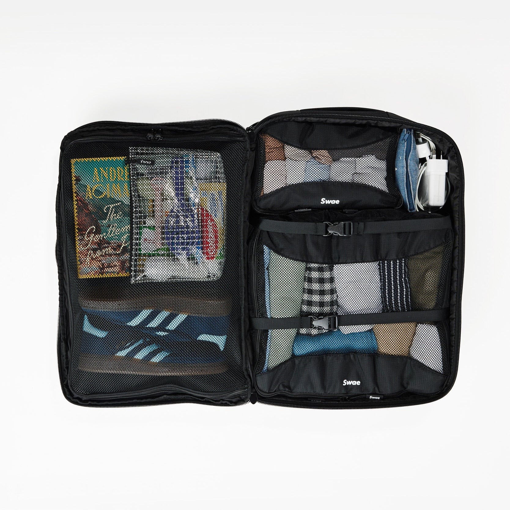 Interior view of the Swae Flow 40L Travel Backpack, featuring a spacious suitcase-style main compartment with a zippered mesh divider, internal compression straps to secure belongings, and an oyster-style opening for easy packing and access.