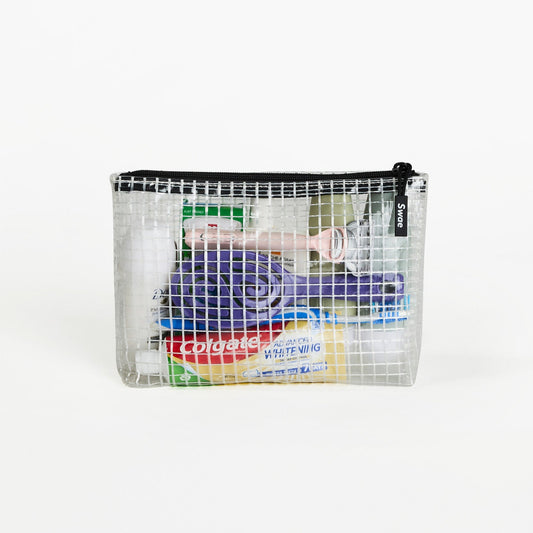 Swae Toiletries Bag packed with skincare, dental care, and travel grooming essentials, showcasing its spacious, transparent mesh design for easy access and organisation.