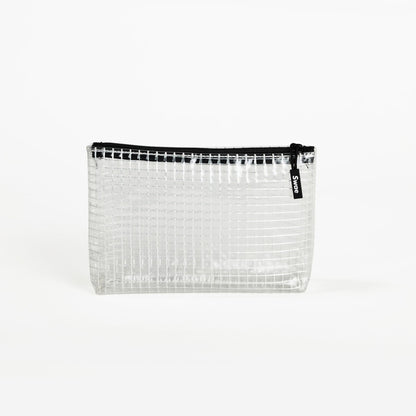 Swae Toiletries Bag – a sleek, tapered travel bag made from transparent coated mesh tarpaulin, designed for easy organisation and quick access to toiletries.